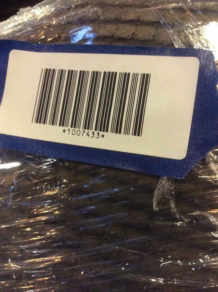 3. Barcode sticker labeled 1007433 on Crate & Barrel sofa, surrounded by protective wrapping.