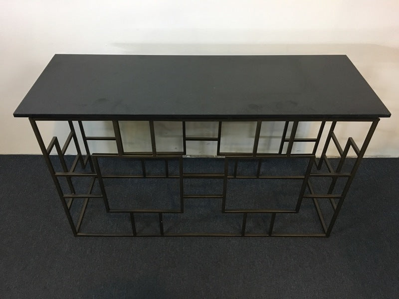 2. Top view of a Reperch end table with a sleek glass surface and intricate geometric metal base.  