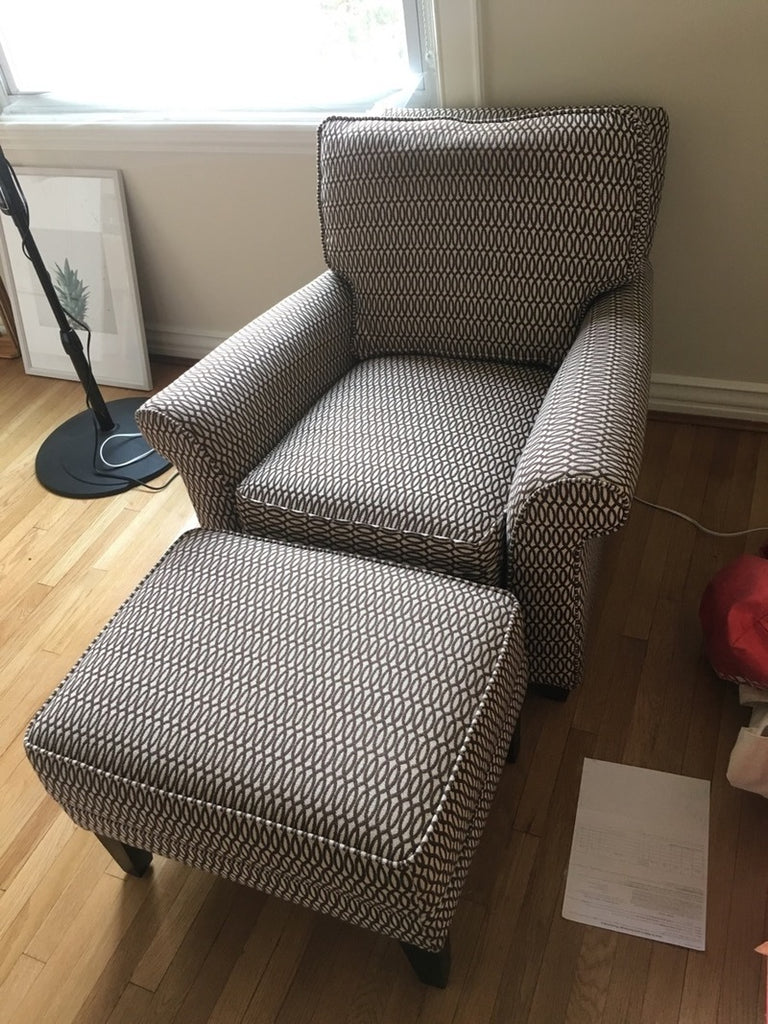 2. Patterned Pottery Barn chair and ottoman in a bright room, featuring a modern, neutral fabric design.