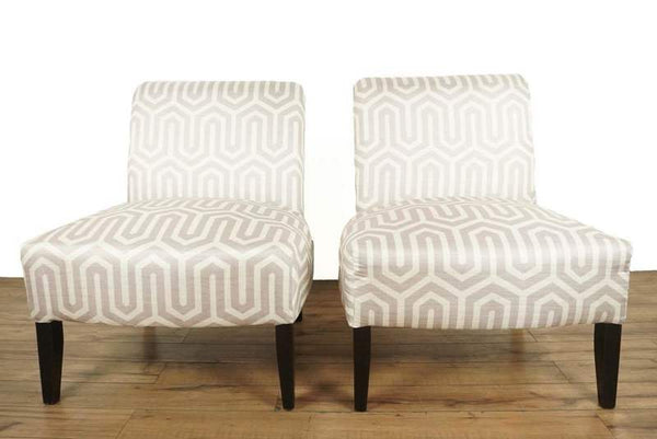 1. Pair of Skyline Furniture chairs with gray and white geometric pattern, set on wood legs, front view.