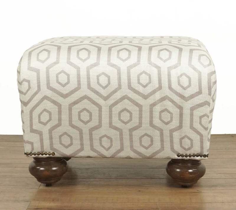 Front view of a Reperch ottoman featuring keyhole pattern silk blend fabric and four rounded wooden legs.