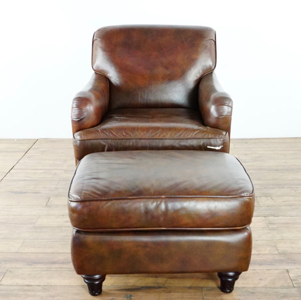 1. Brown leather Lane Furniture chair and ottoman set with paint mark on chair cushion rim, on wooden floor.