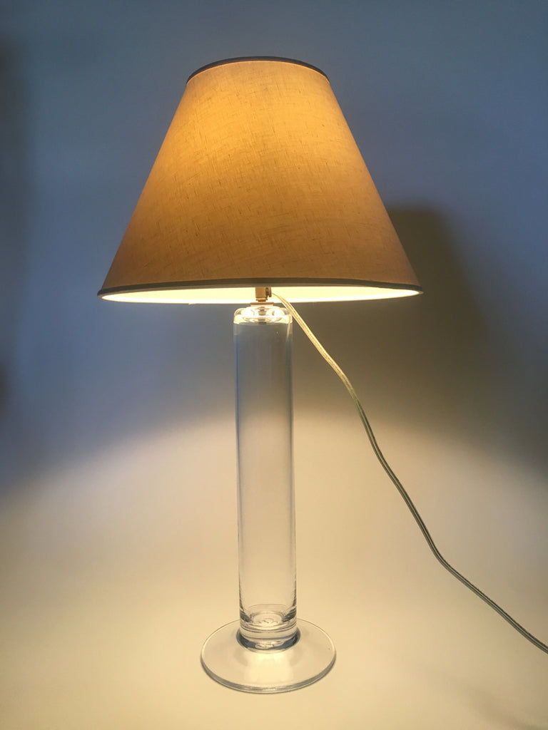 3. Modern lamp with a glowing linen shade and cylindrical glass base by Simon Pearce, power cord attached.