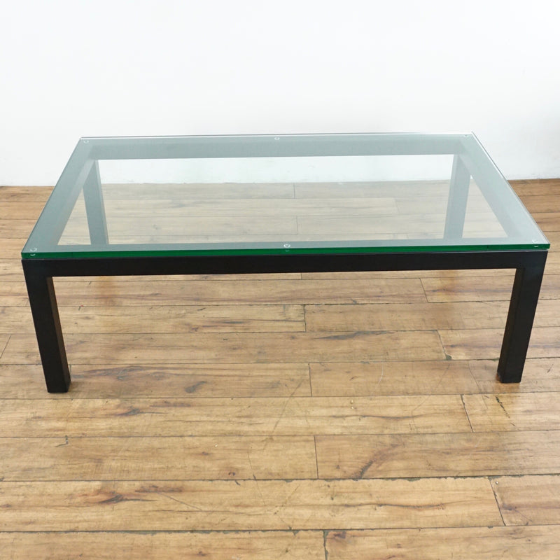 2. Rectangular glass-top coffee table by Crate & Barrel, featuring a wooden frame, viewed from above.