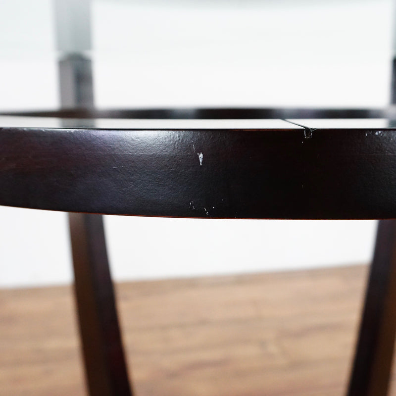 3. Close-up of Ethan Allen dining table’s dark wooden base, showing minor surface scuffs and finish wear.