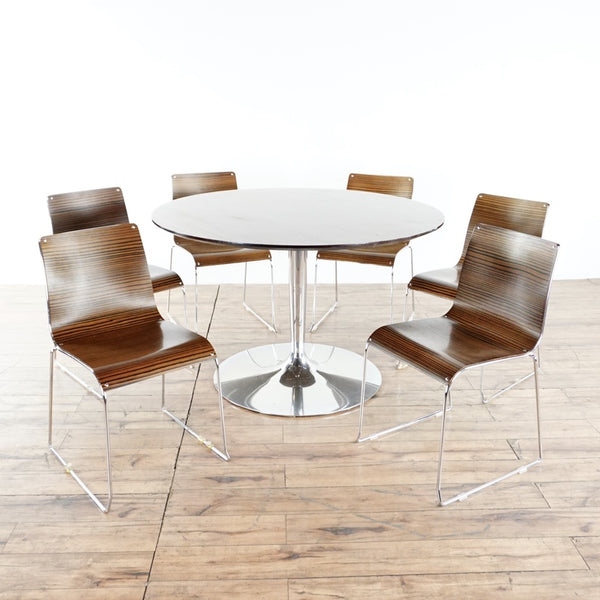 1. Calligaris Macassar dining set with round chrome base table and six stackable wood chairs on wood floor.