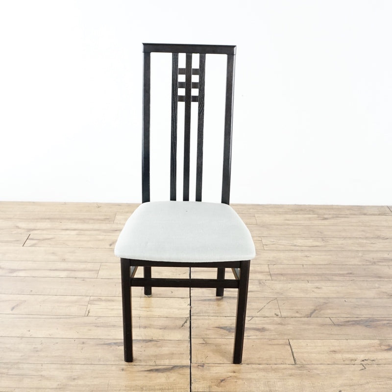 3. Front view of an Italian IMS dining chair with geometric black frame and new light-colored upholstery on seat.