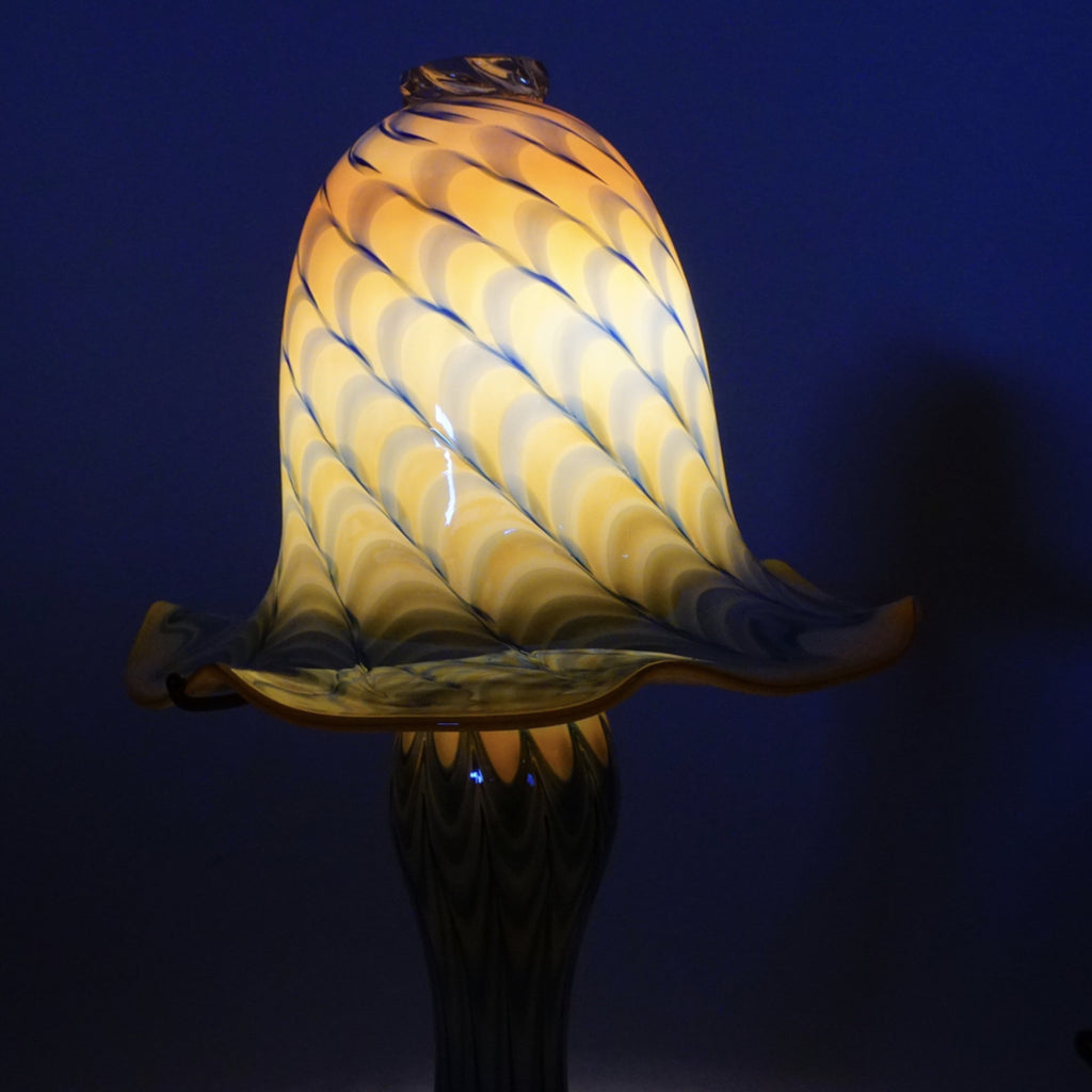 2. Close-up of the Reperch Tiffany style glass lamp lit in a dark room, showing its glowing patterned shade.