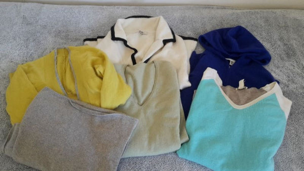 1. Assorted women’s Reperch sweaters in yellow, blue, aqua, grey, white, and light green displayed on a grey surface.