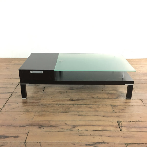 1. Contemporary Reperch coffee table with two drawers, opaque glass top, and chrome fittings on wooden floor.