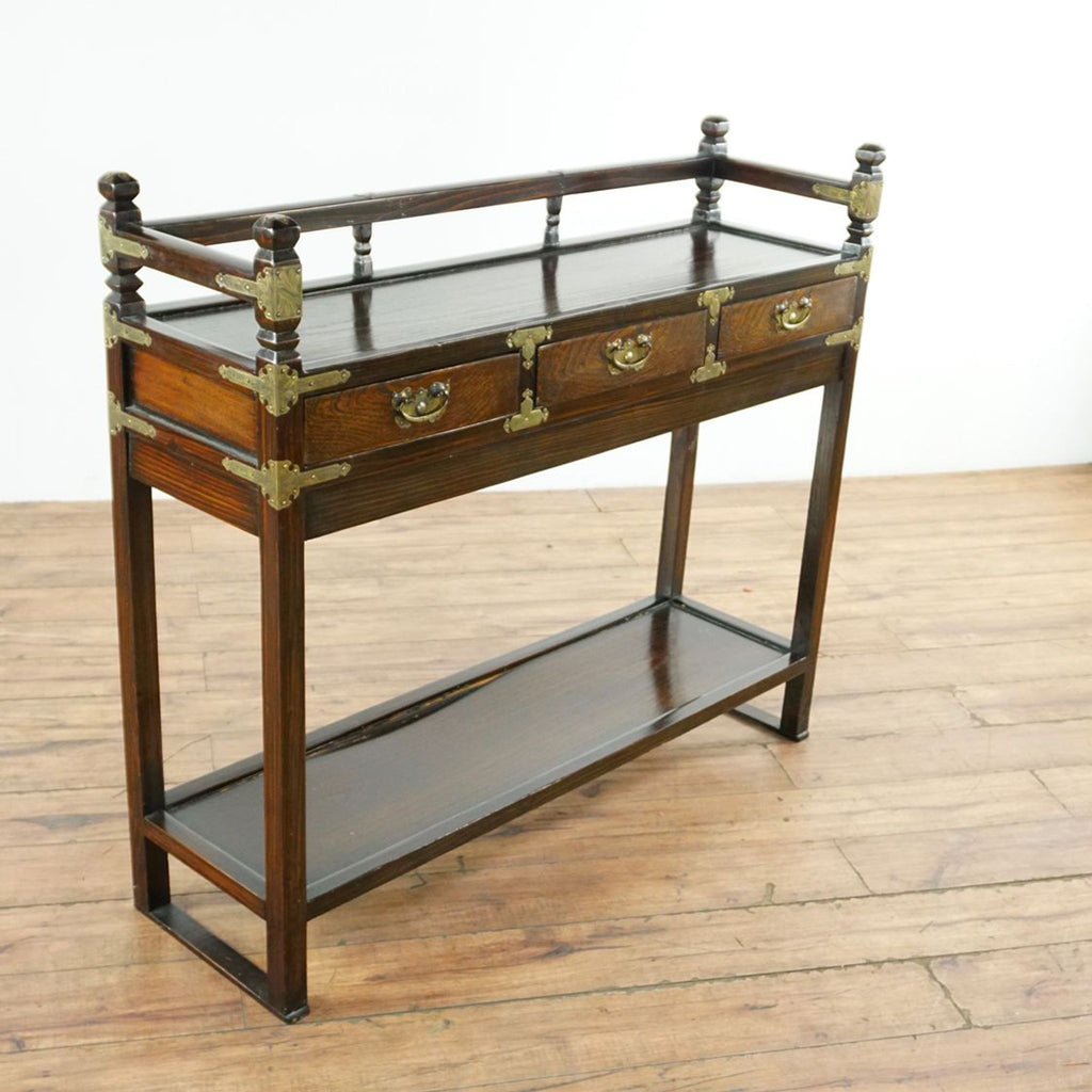 3. Angled view of Reperch side and console table featuring brass fittings, three drawers, and a bottom shelf.