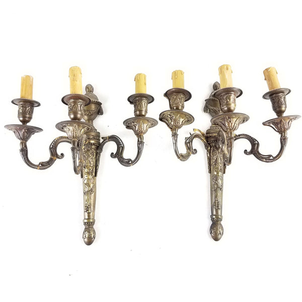 Pair of ornate gilt bronze Reperch wall sconces with detailed classical motifs and faux candle lights.  