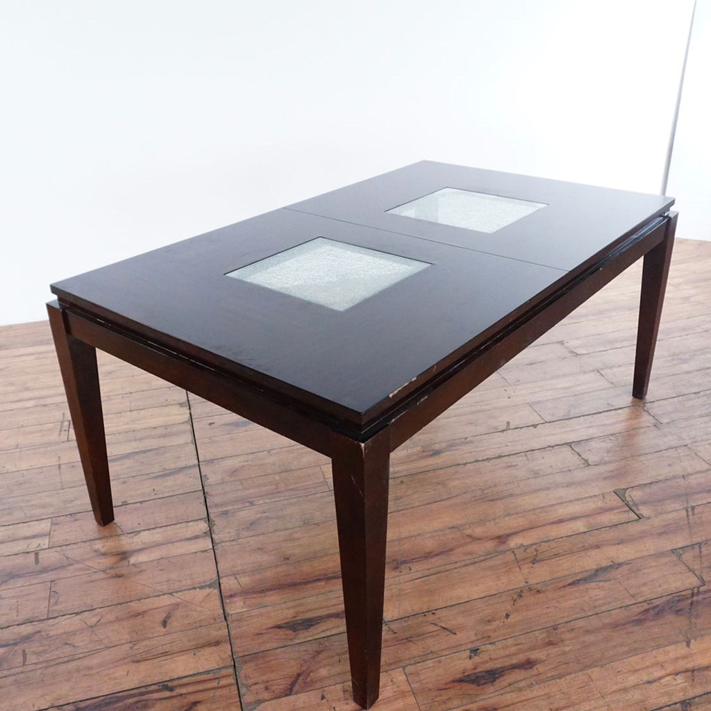 3. Angled view of expandable Reperch dining table showcasing two crackle glass insert panels in dark wood.