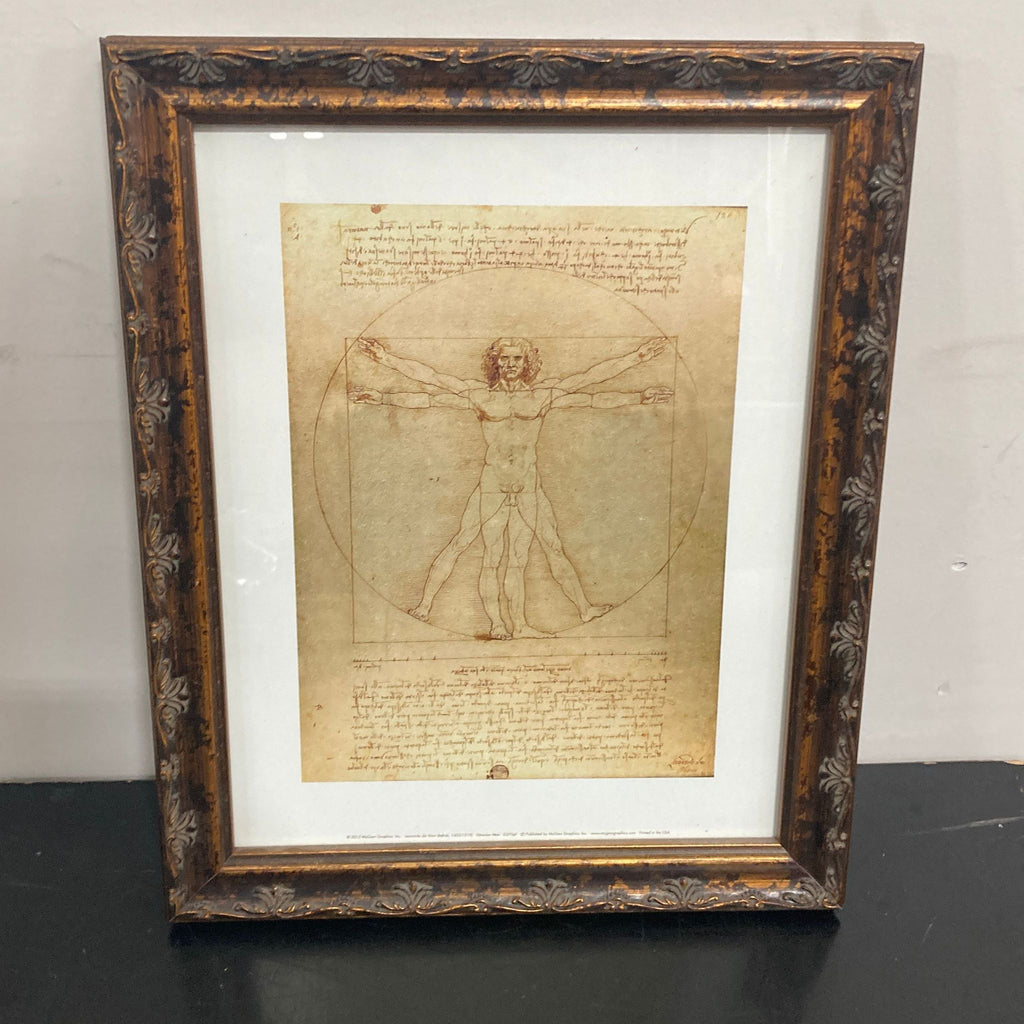 1. Framed print of Leonardo da Vinci's Vitruvian Man drawing by Reperch, in decorative brown frame, front view.