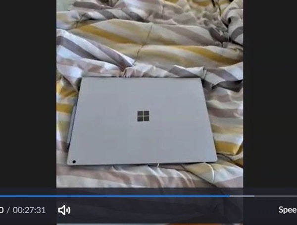 Microsoft Surface device on striped bedding.