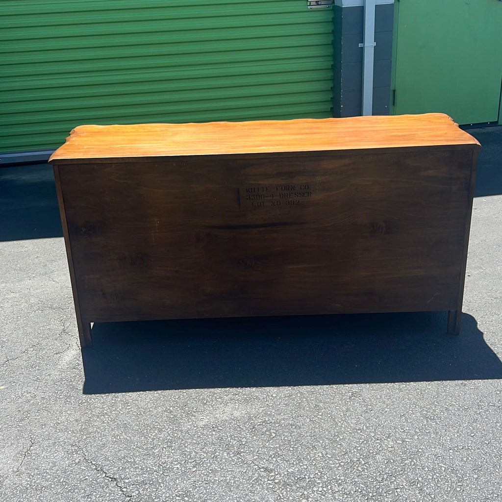 a wooden bench sitting on top of a sidewalk 