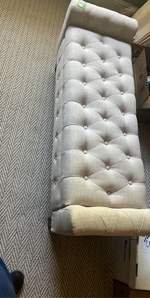 a bed with a white blanket and a black pillow 