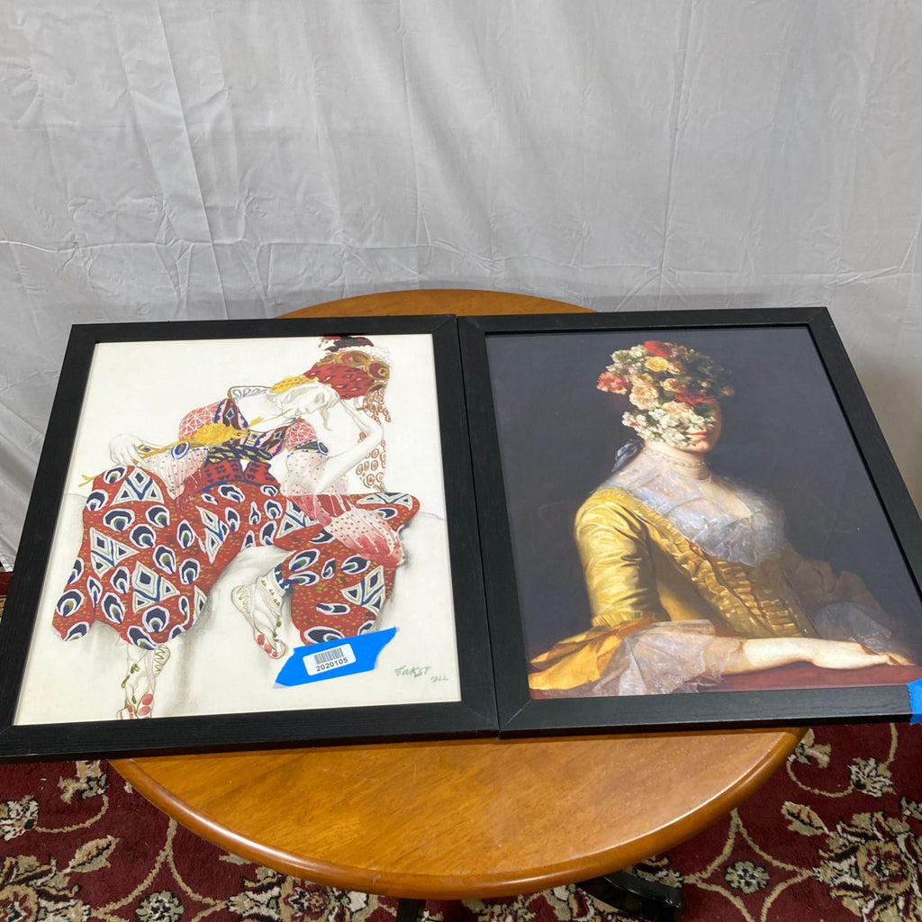 1. "Two framed Reperch art prints on a table, one depicting a colorful abstract figure, the other a woman with a floral headpiece."