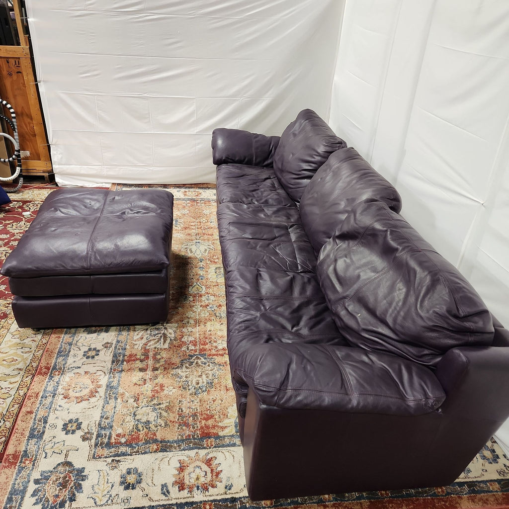 a leather couch and ottoman in a room.