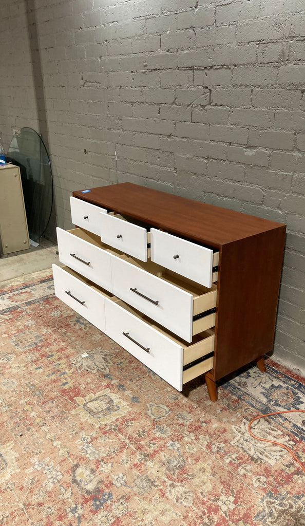 a mid century modern dresser with three drawers.