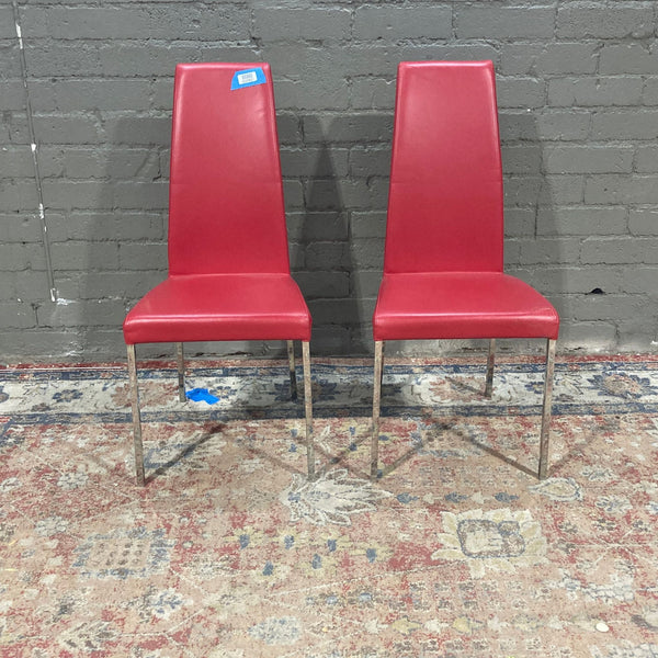 two red chairs sitting next to each other 