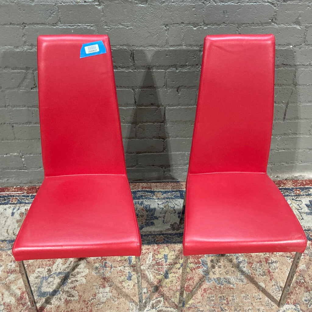 two red chairs sitting next to each other 