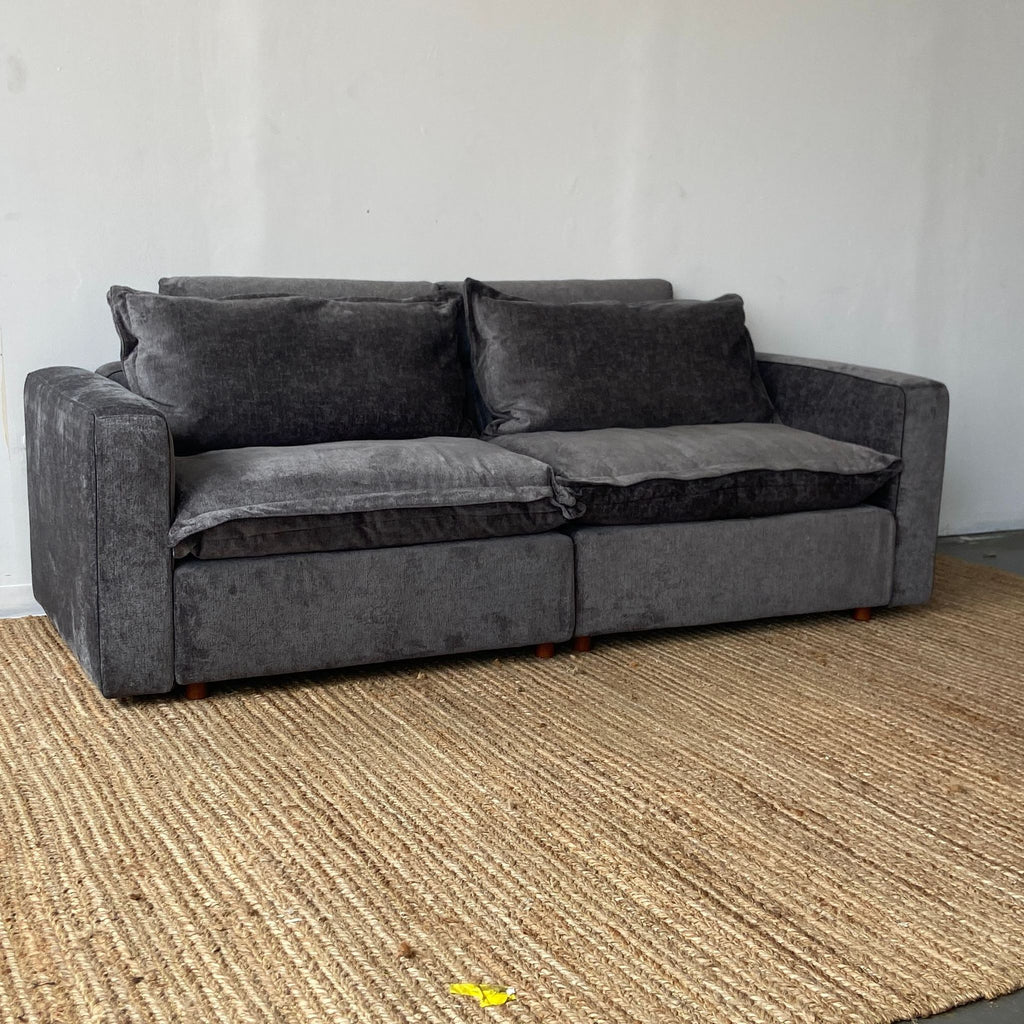 a couch with a black couch cushions and a black rug 