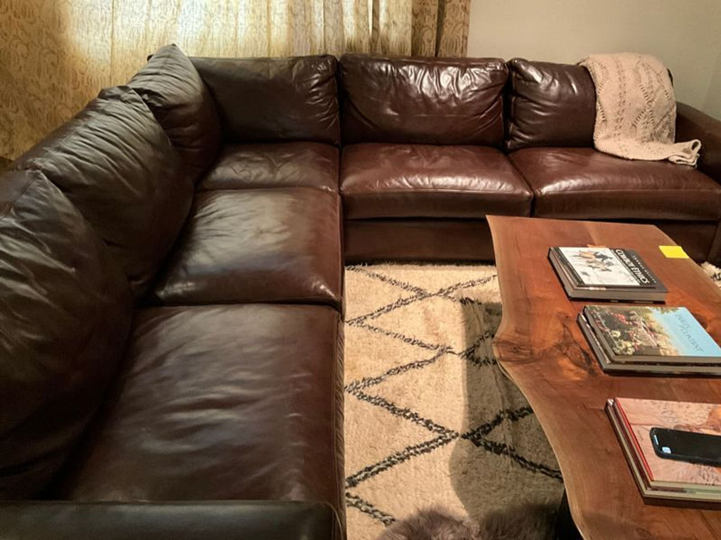 a living room with a couch, coffee table and a bookcase 