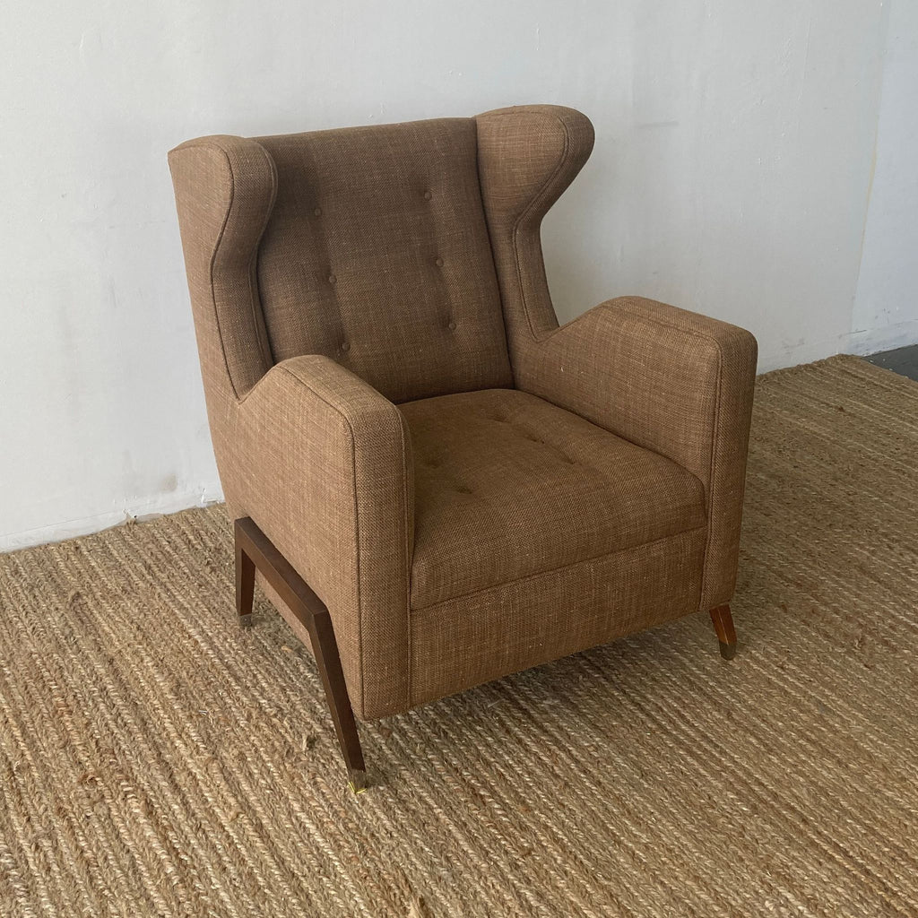 Classic wingback lounge chair featuring tufted brown fabric and unique angled legs.