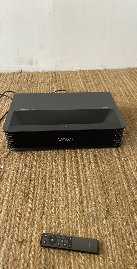 VAVA Chroma 4K UST Projector with remote on a woven fabric surface, showcasing sleek design.