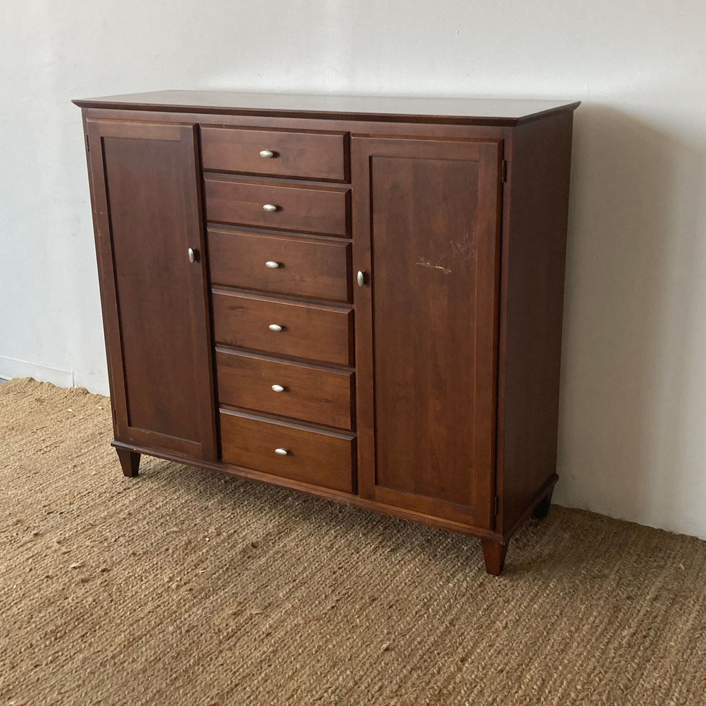 Wooden Ethan Allen dresser, featuring a central column of drawers.