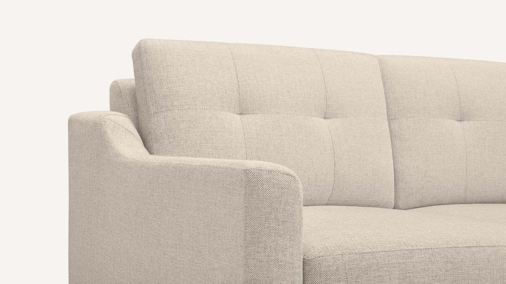 Close-up of beige Burrow Nomad sofa design with tufted backrest.