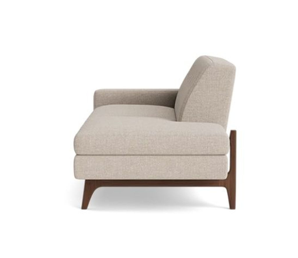 Side view of a beige sofa with a sleek design and sturdy wooden legs.