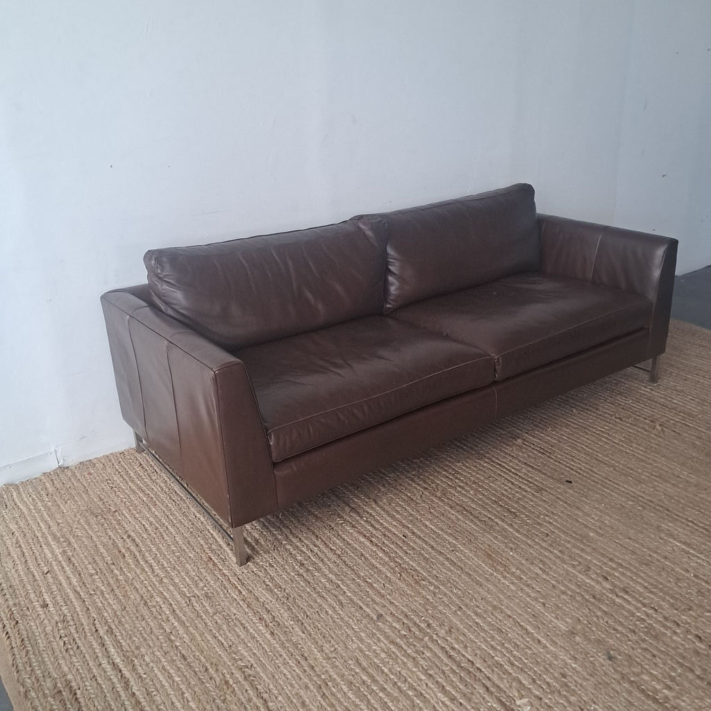 Side view of a brown leather Crate & Barrel 3-seat sofa.