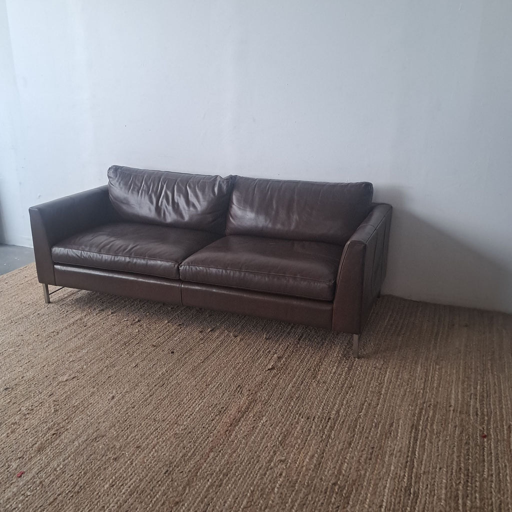 Crate & Barrel leather sofa, 3-seater, on a textured rug.