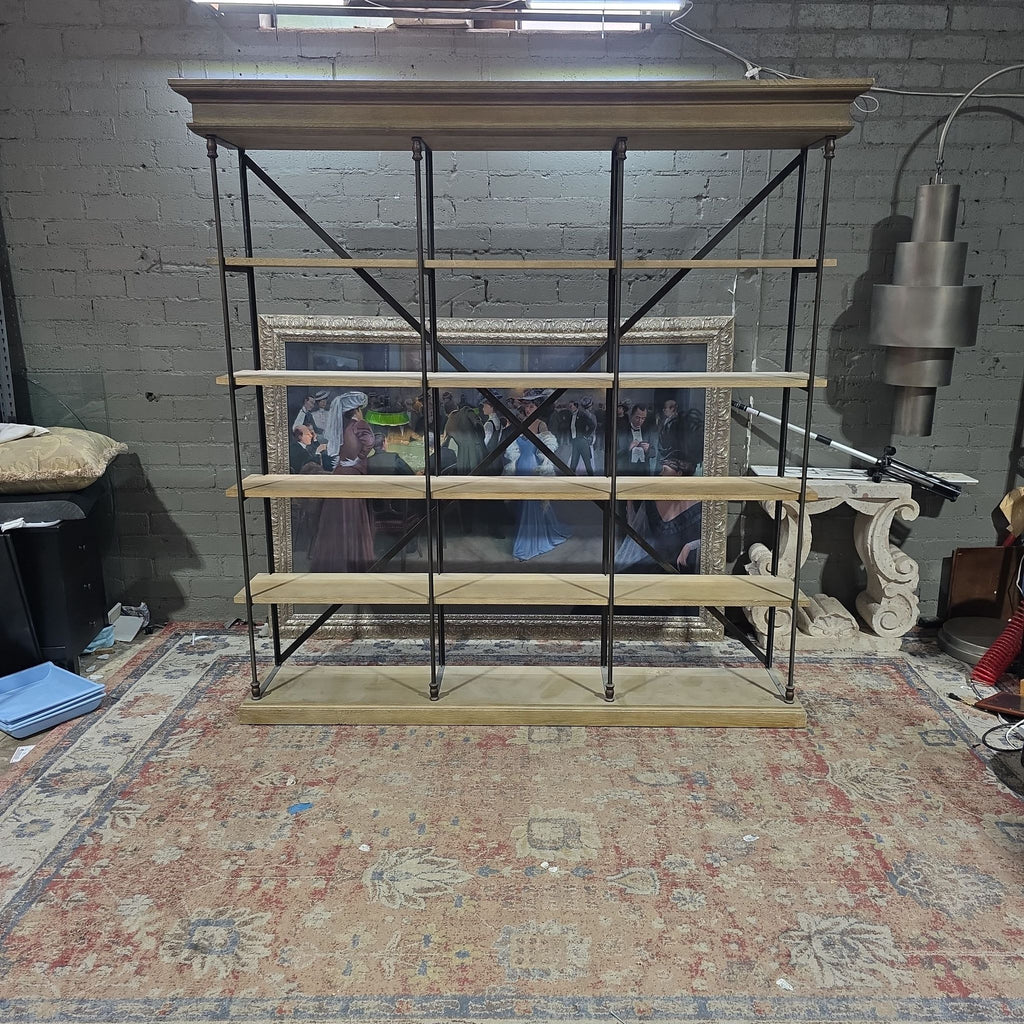 1. Restoration Hardware bookshelf with wood shelves and black metal frame, shown against a brick wall in an industrial room.