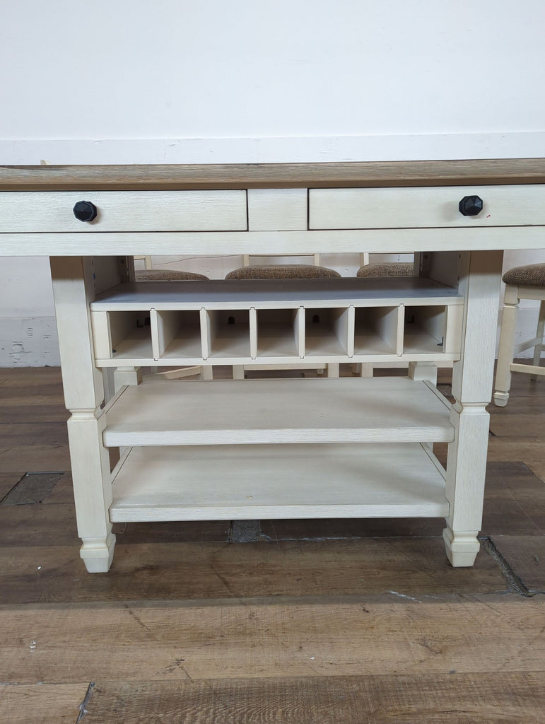 3. Close-up of Ashley Furniture dining table showing drawers, bottle storage, and two lower shelves.