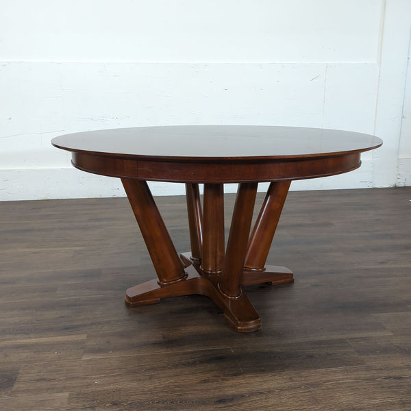 1. Round Reperch dining table with dark wood finish and angled legs, displayed on wood flooring.  