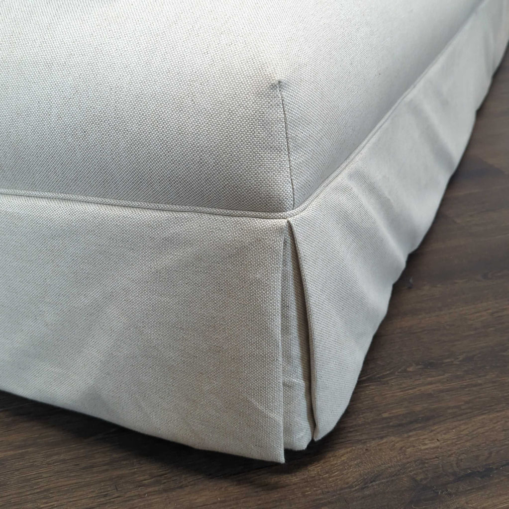 3. Close-up of the skirted corner and fabric texture of the beige Shoppe Amber Interiors 3-seat sofa.