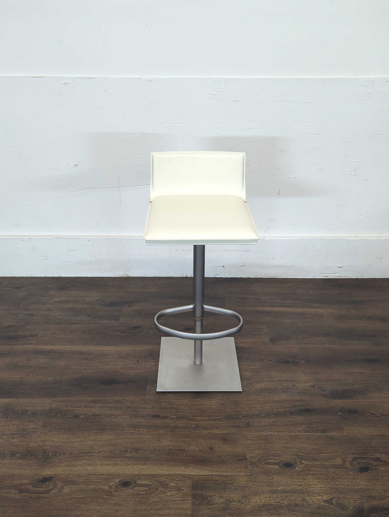 3. Contemporary counter stool with a stain-resistant leather seat, metal frame, and 360-degree swivel functionality.