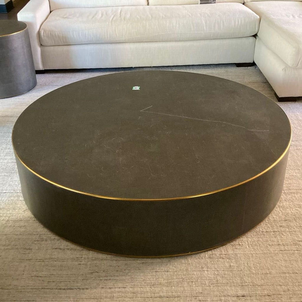 Restoration Hardware round coffee table with black finish and brass trim, offering a modern look.