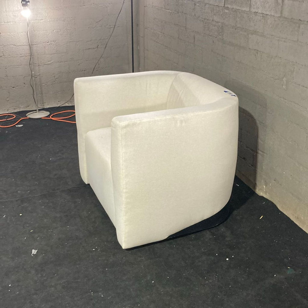 1. Modern ivory lounge chair by Maiden Home with squared arms, set against a concrete wall and dark floor.