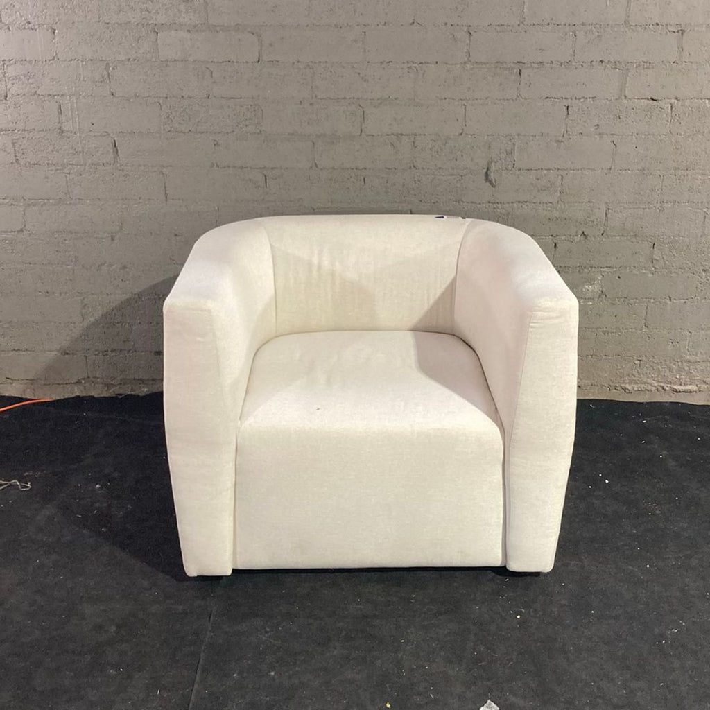 2. Front view of a minimalist Maiden Home lounge chair in light fabric, suitable for contemporary interiors.