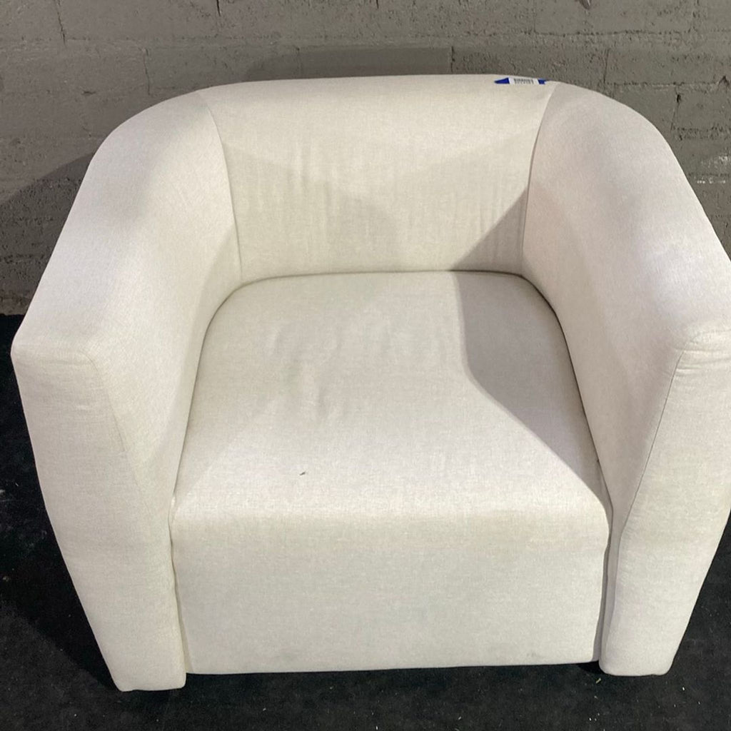 3. Close-up of the Maiden Home lounge chair’s smooth, curved back and seat in a light, neutral color.