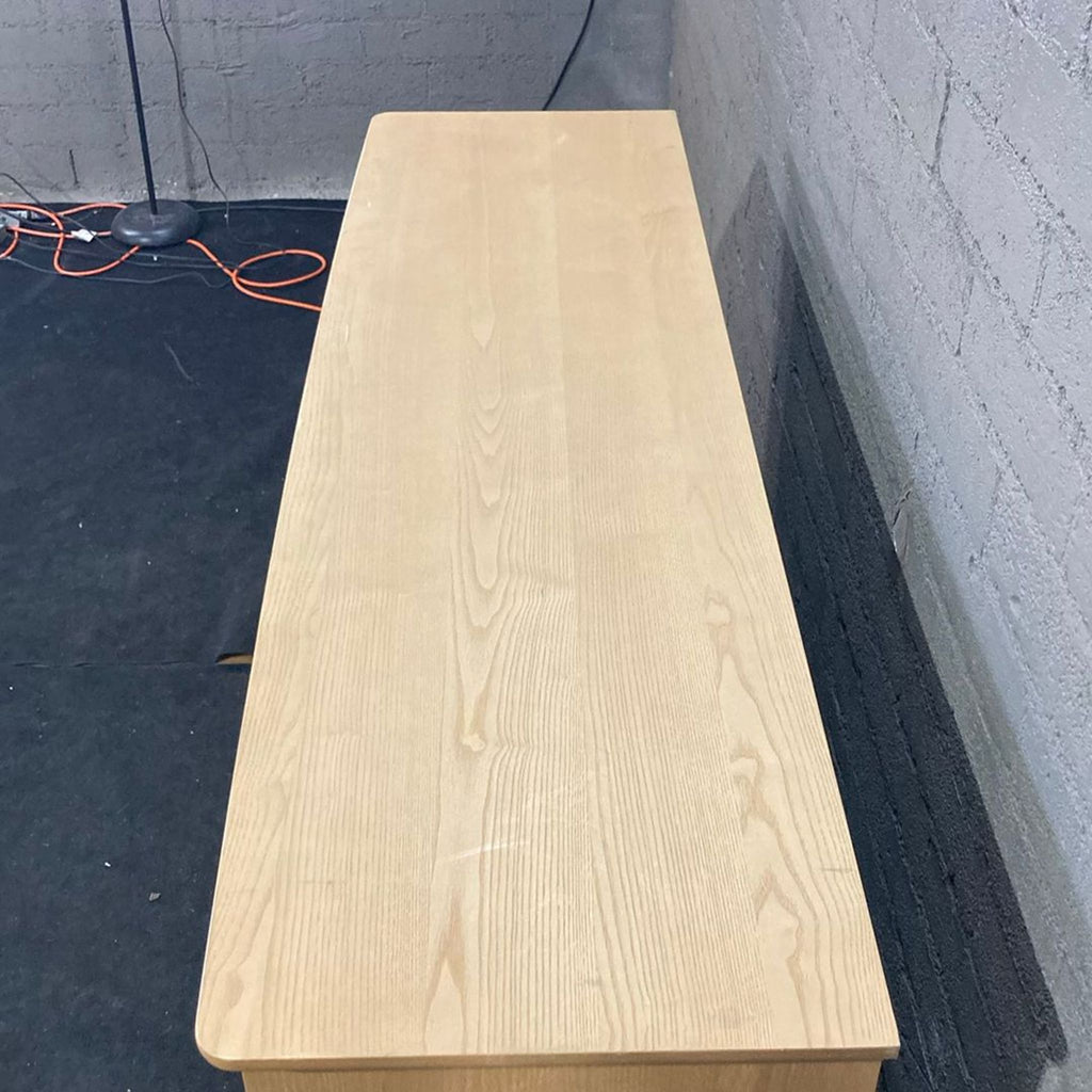 3. Top view of a rectangular natural wood Living Spaces dresser, highlighting the smooth surface and subtle grain.