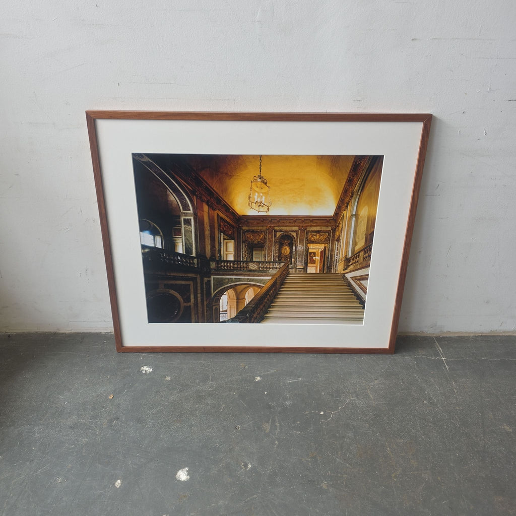 Professionally framed art print of an ornate staircase in a grand hallway, featuring warm tones and classic style.  
