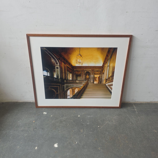 Professionally framed art print of an ornate staircase in a grand hallway, featuring warm tones and classic style.  
