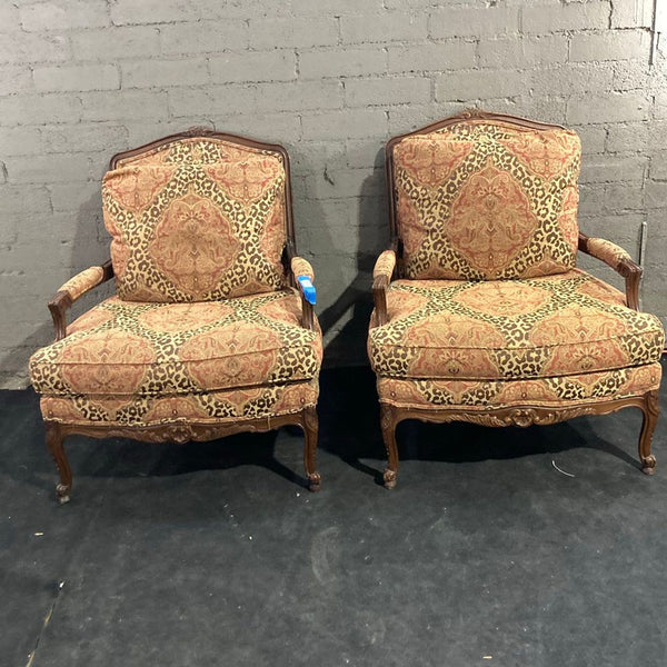 Pair of Sherrill armchairs with curved wooden arms and patterned cushions, perfect for lounge spaces.  