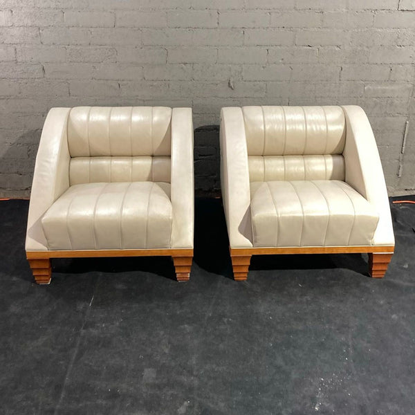 Pair of Giorgetti lounge chairs with cream leather upholstery and wooden bases, featuring deep seats and curved arms.