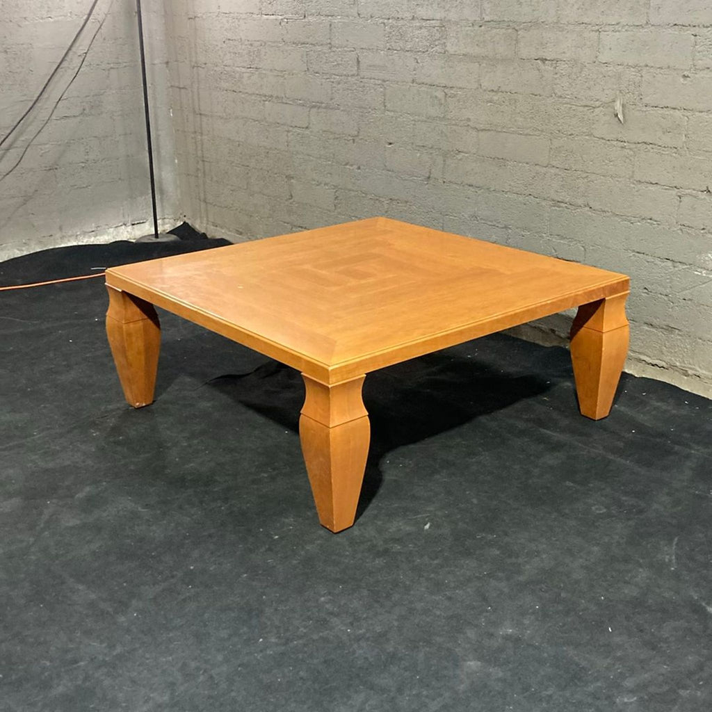 2. Angled view of a Giorgetti square coffee table showing elegant wood grain and sculpted legs in a modern room.